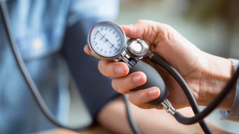 Close-up of a healthcare provider measuring blood pressure with a sphygmomanometer