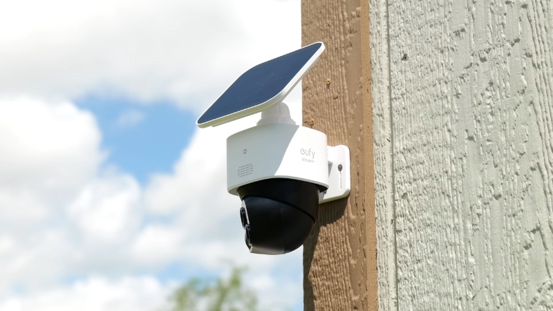 A solar-powered outdoor security camera mounted on a wall records footage to enhance smart home safety