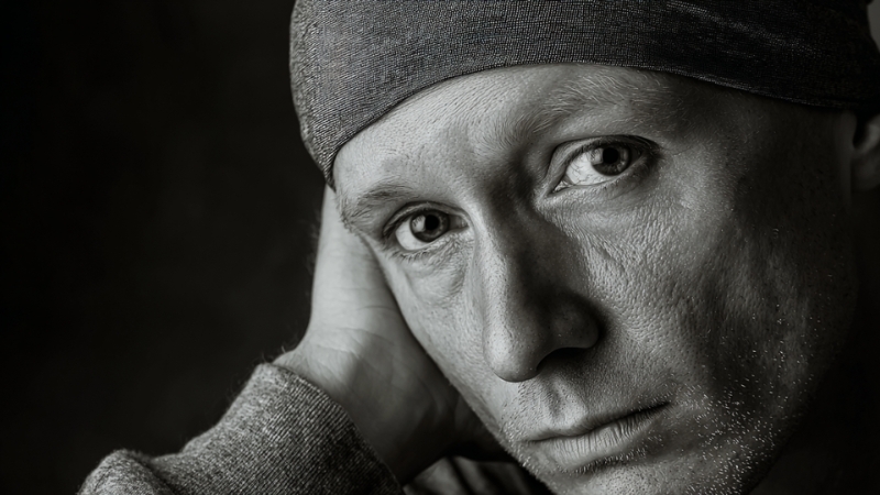 Portrait of a cancer patient wearing a headscarf, reflecting resilience during treatment