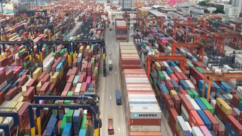 Aerial view of a shipping port with stacked containers, highlighting the global supply chain shifts amid U.S.-China trade tensions