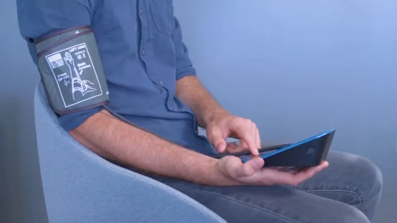 A man uses a tablet to record his blood pressure data, illustrating RPM by the Numbers in real-world patient monitoring