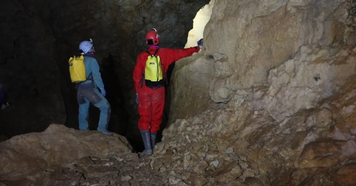 Two researchers explore a cave passage where the ancient climate record was collected