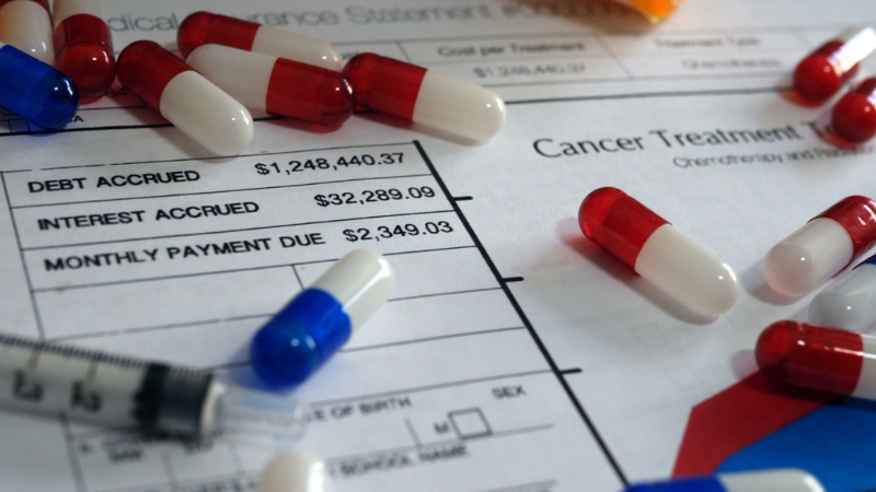Medical bills and capsules on a table highlight the high cost of modern cancer treatment