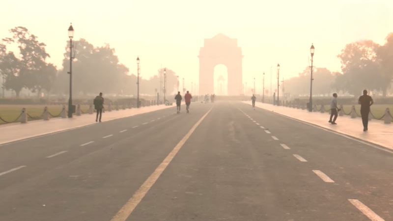 People walk through heavy smog near India Gate during Delhi’s smog crisis
