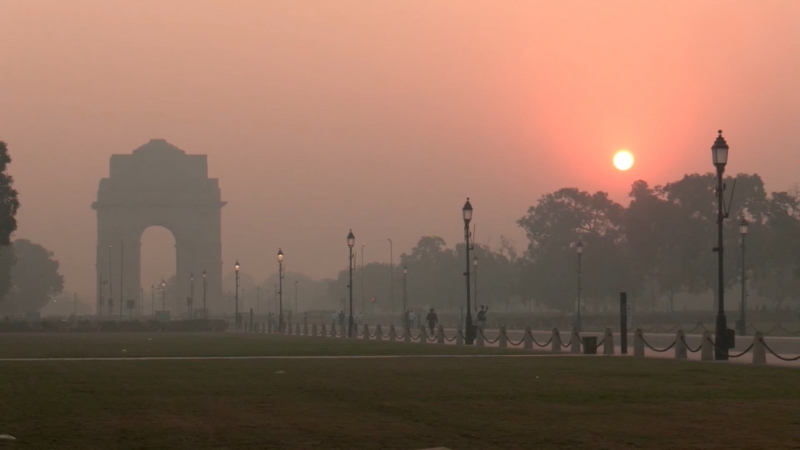 Morning haze over India Gate during Delhi’s smog crisis, with the sun barely visible through the heavy air pollution