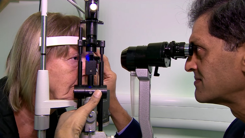 An eye doctor examines a patient with a slit lamp after an eye treatment