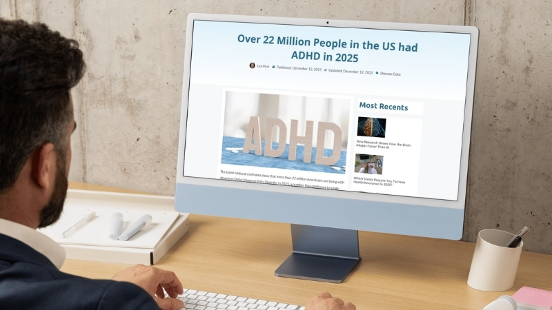 Person at a desk views an ADHD statistics article on a desktop screen