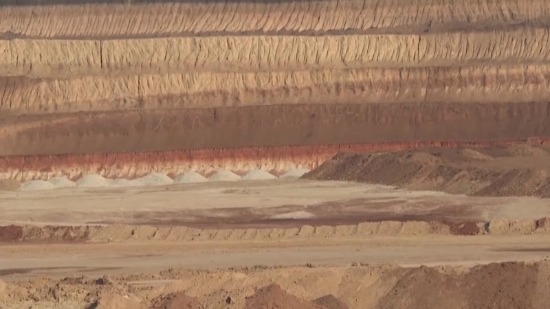 Layers of exposed earth in a large open mining area