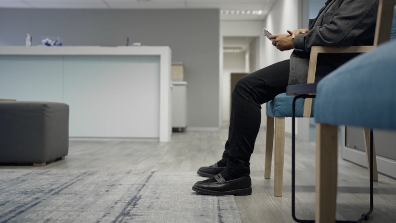 Patient sits in clinic chairs as doctor and specialist appointment delays persist across the United States