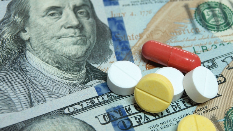 Prescription pills on US dollar bills highlight tax rules behind employer medical reimbursements
