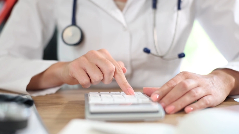 Doctor calculate health insurance costs on a calculator during coverage review