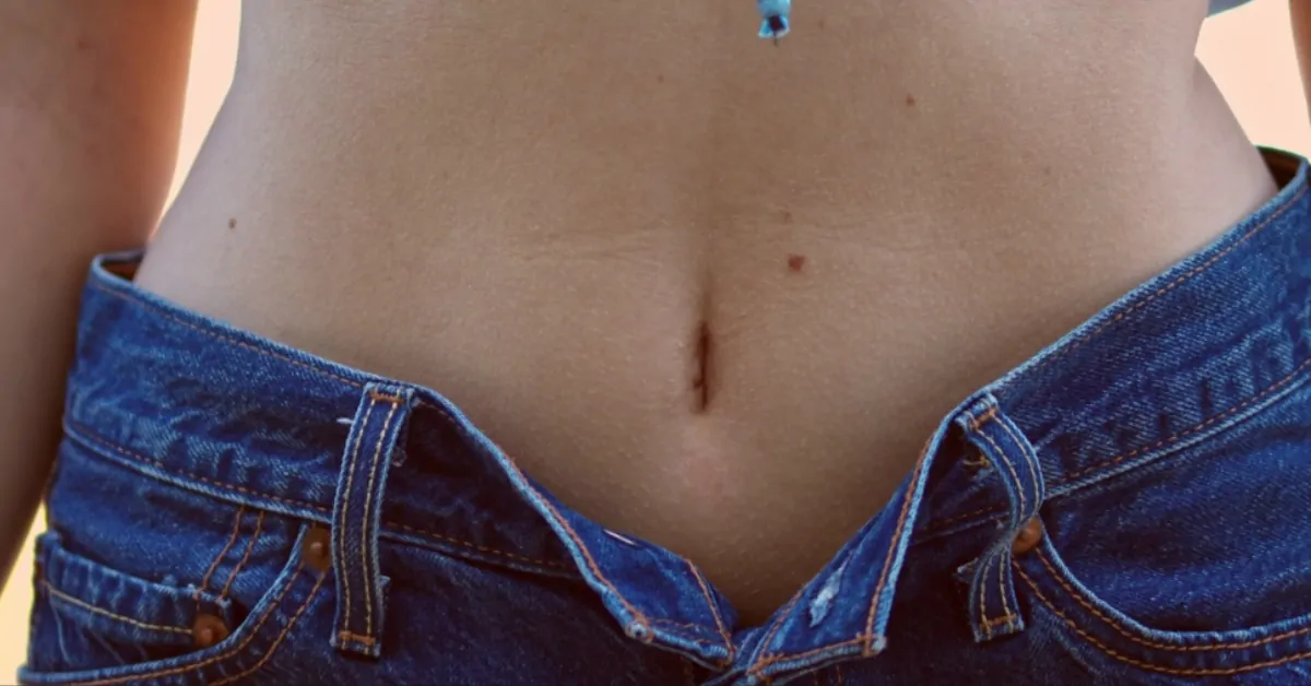 Close-up of a person’s belly button and abdomen showing the navel area where diverse bacteria live