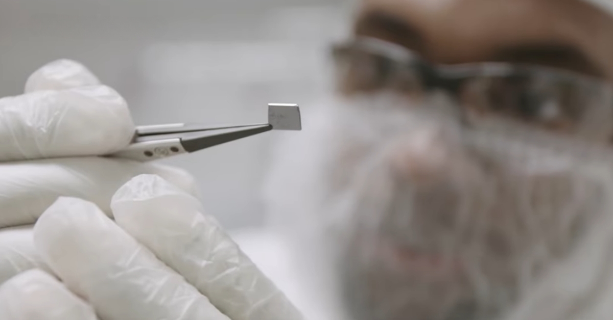 A surgeon holds a tiny chip with tweezers before implantation to help blind people regain vision