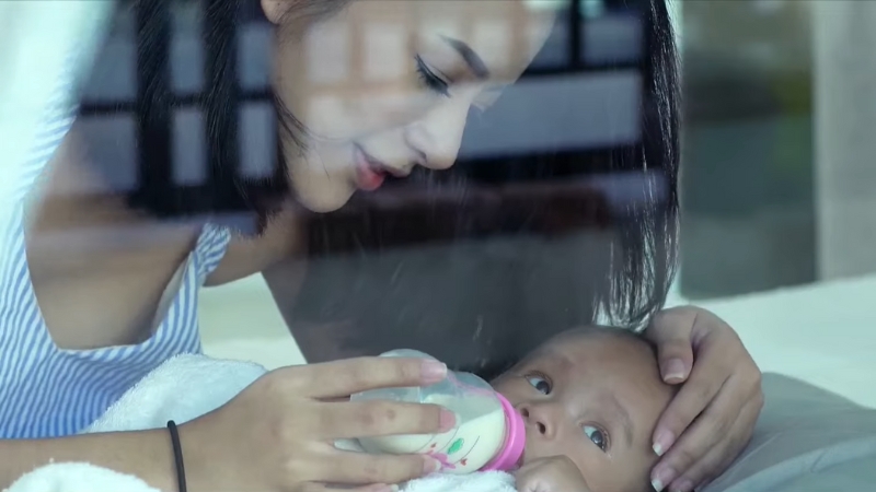 Mother bottle-feeds her infant, a quiet moment that reflects China’s low fertility rate