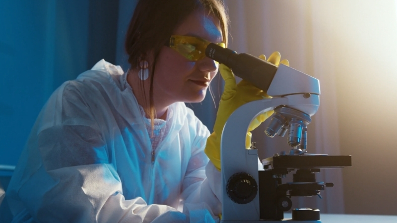 Scientist studies infectious disease viral threats under a laboratory microscope