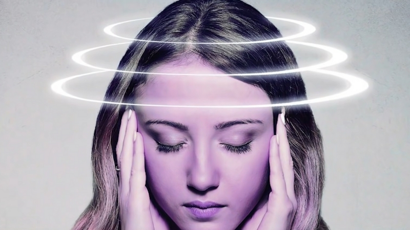 Woman holding her head with visual rings suggesting symptoms reported in Havana Syndrome cases