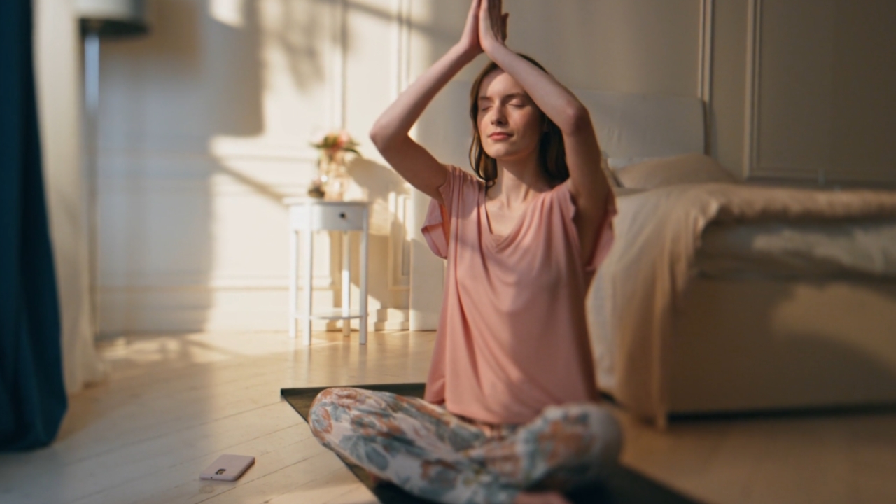 Woman meditating on a yoga mat at home, reflecting the theme meditation isn’t always peaceful