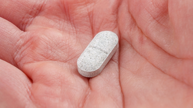Close-up of a pill resting in a person’s palm, symbolizing medication and substance risk in midlife