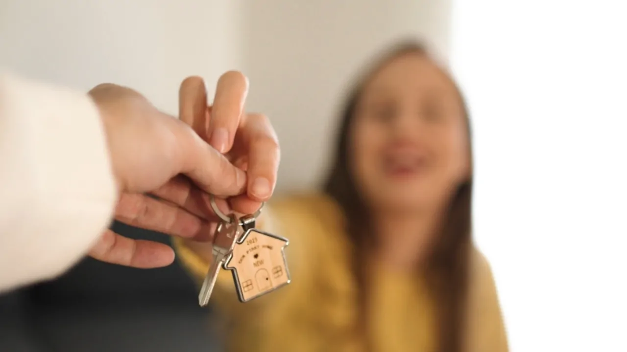 Keys are handed to a young woman, highlighting housing challenges for many Gen Z workers