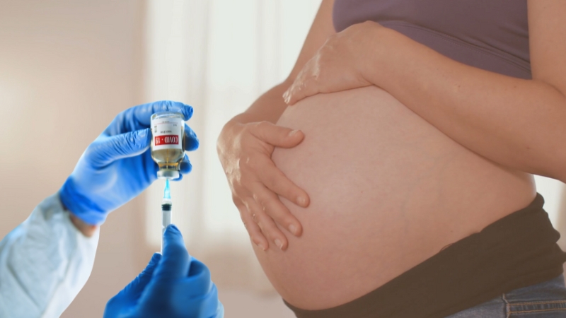 Healthcare worker prepares a vaccine injection near a pregnant woman’s abdomen