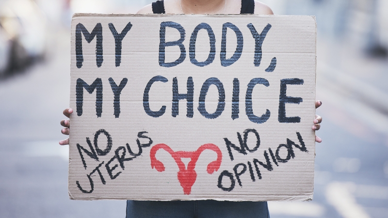 Person holding a protest sign that reads “My Body, My Choice” in support of abortion rights