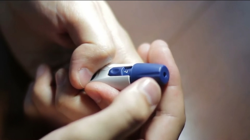 Close-up of a person holding a GLP-1 injection pen used for diabetes treatment