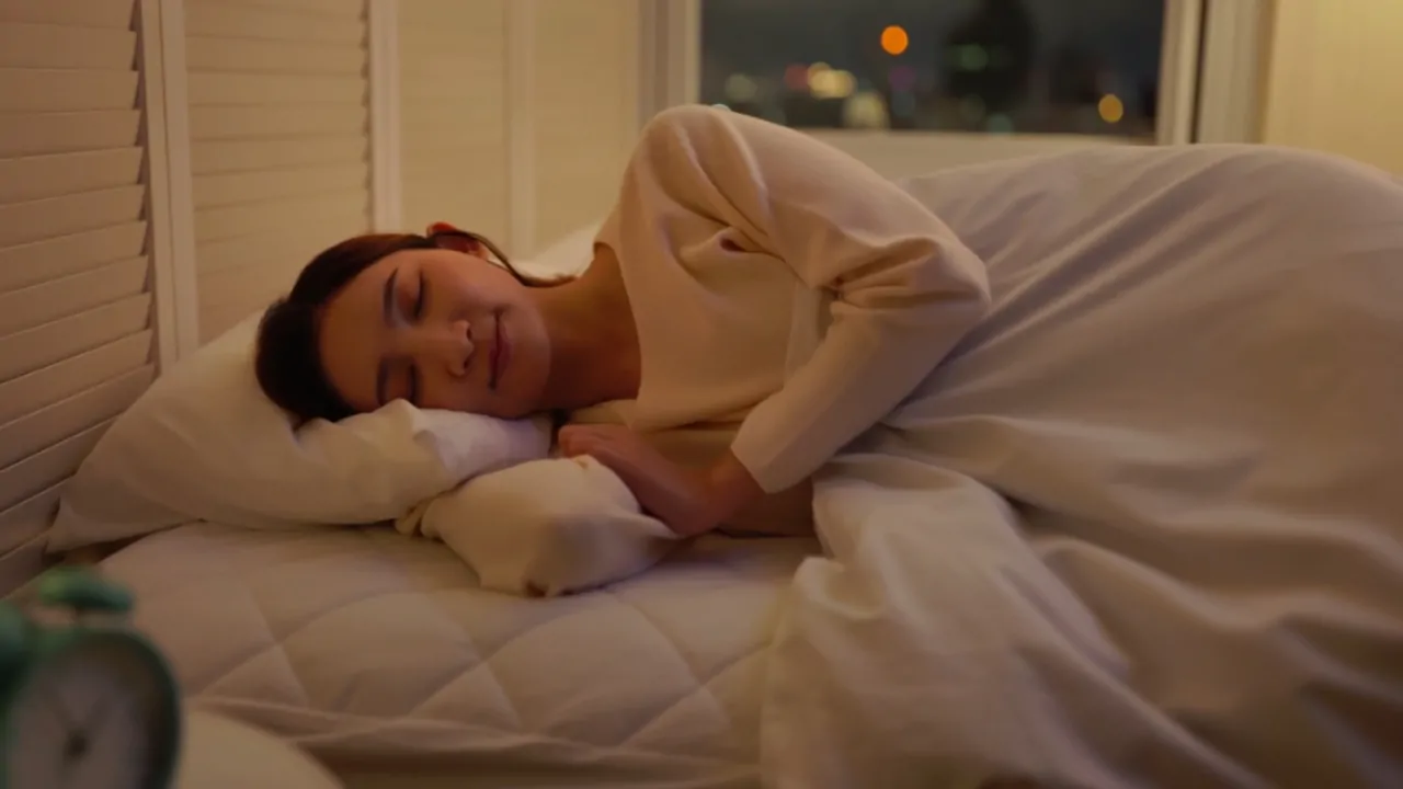 Woman asleep peacefully at night, showing how one unexpected habit can boost happiness