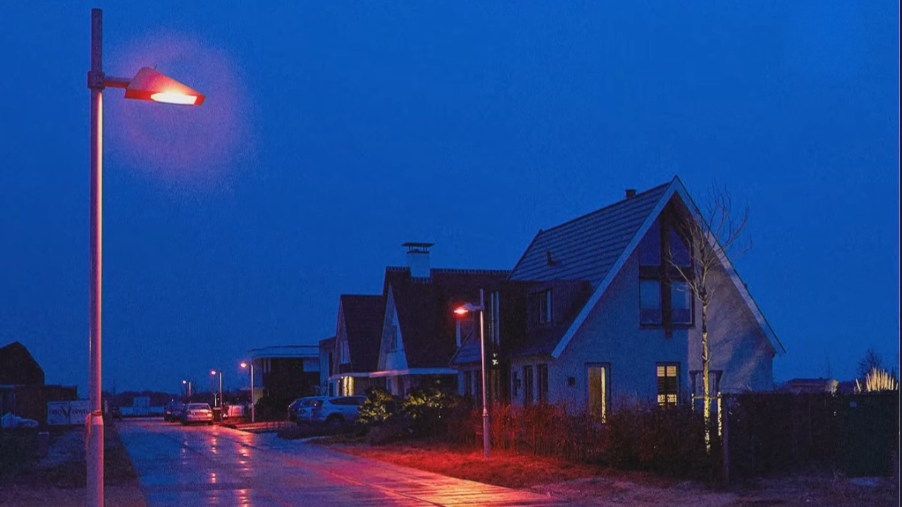 Red streetlights illuminate a quiet residential street in Denmark at night to reduce light pollution and protect wildlife