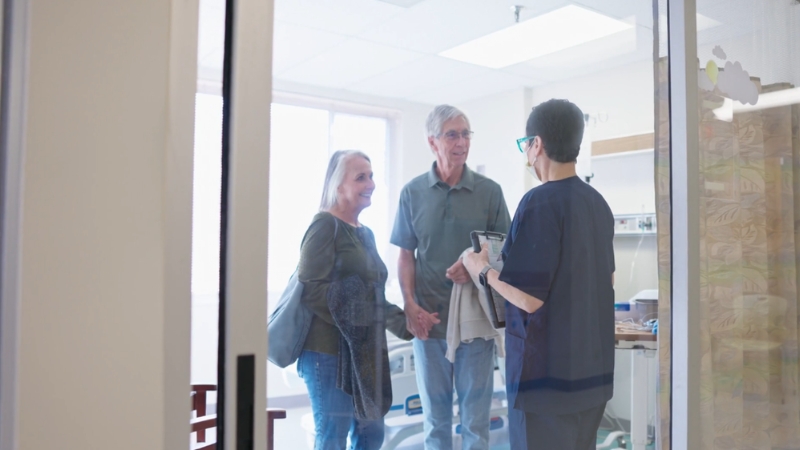 Nurse speaks with a couple in a hospital room during patient discharge discussion