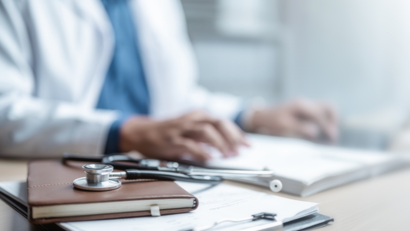 Doctor reviewing documents related to hospital indemnity insurance rules and patient protections