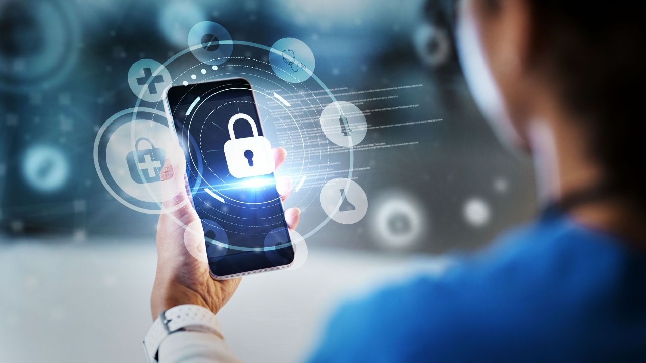 Hospital worker viewing a secure mobile dashboard that protects patient data through modern health IT cybersecurity systems