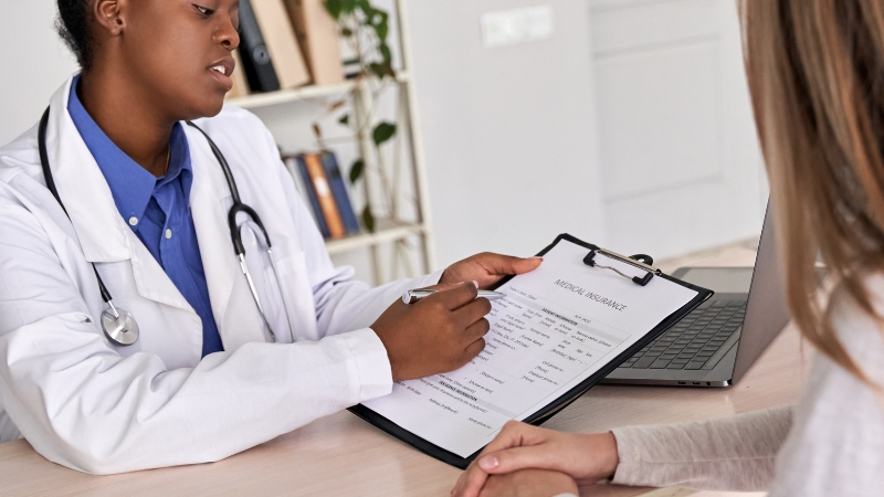 Doctor explaining hospital indemnity insurance coverage details to a patient during a medical consultation
