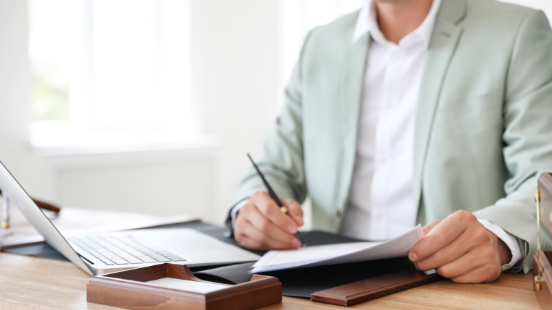 Counseling program administrator reviewing accreditation documents at a desk