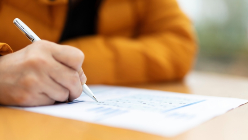 Candidate completing paperwork before the NCLEX-RN exam at a testing center