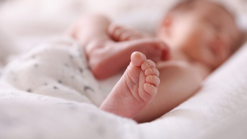 Close-up of a newborn’s feet resting on a soft blanket