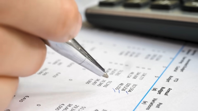 Person reviewing medical bills, showing key drivers of healthcare costs in 2026