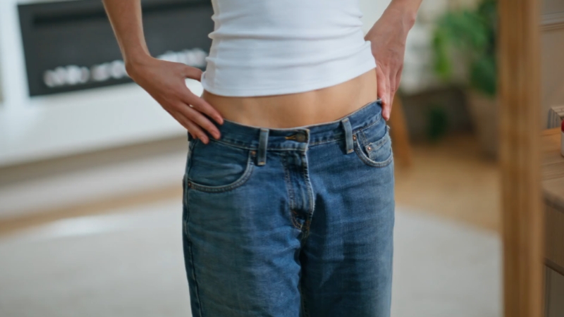Woman measuring her waist to track healthy weight and hormone balance