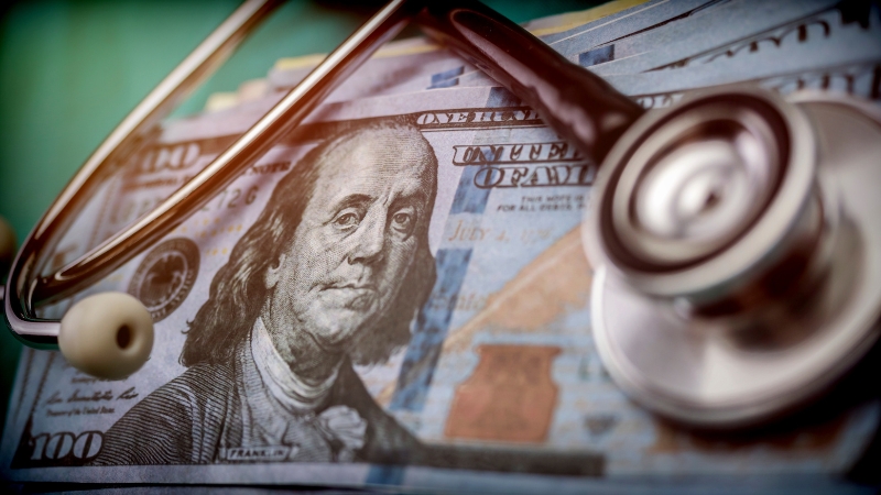 Stethoscope on a dollar bill, showing Medicaid per-enrollee spending costs