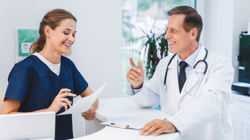 Doctor and nurse reviewing documents, showing primary care investment improving healthcare costs