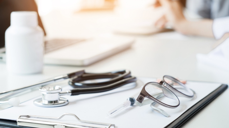 Medical chart and stethoscope on a desk representing hospital diagnosis and billing codes