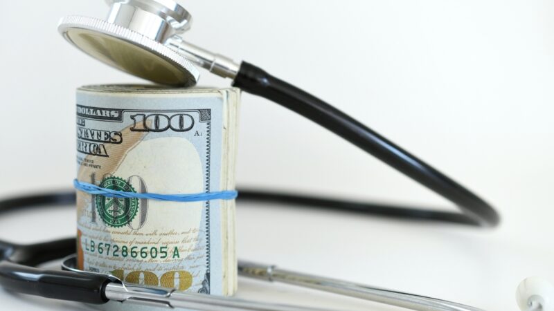 Stack of US dollar bills with a stethoscope placed on top