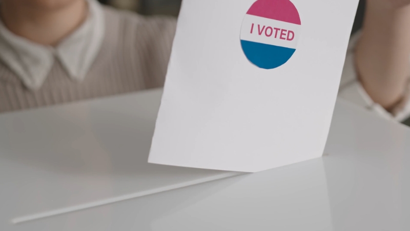 Ballot with an “I Voted” sticker placed into a voting box during a U.S. election