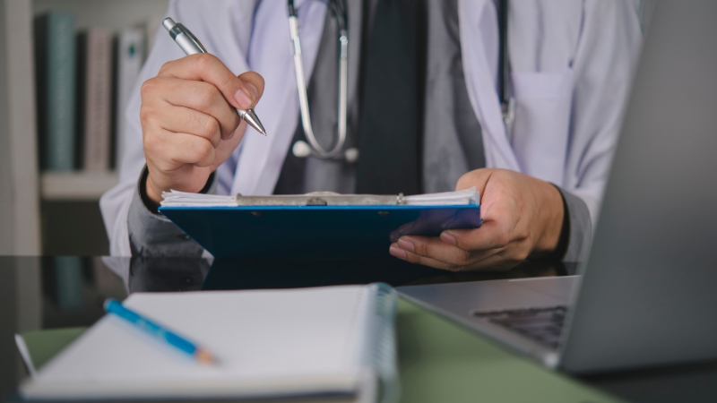 Doctor reviewing patient records related to hospital indemnity insurance coverage