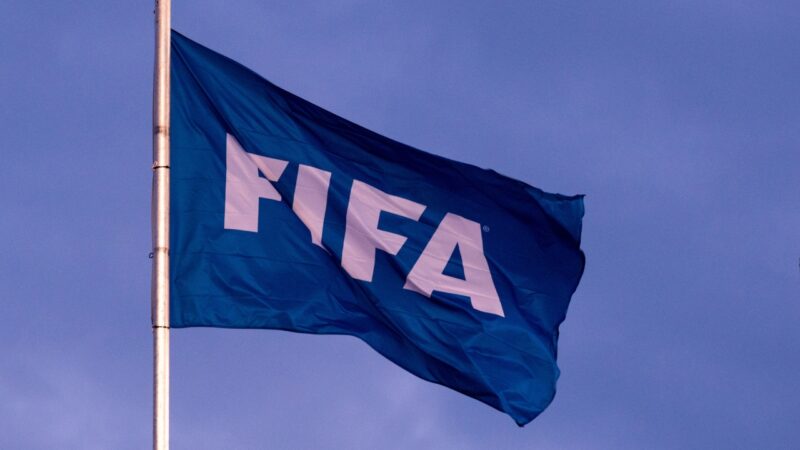 FIFA flag waves on a pole against the sky