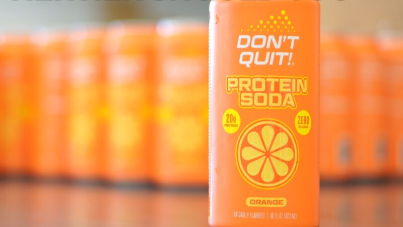 Orange protein soda can with 20g protein and zero sugar label in focus