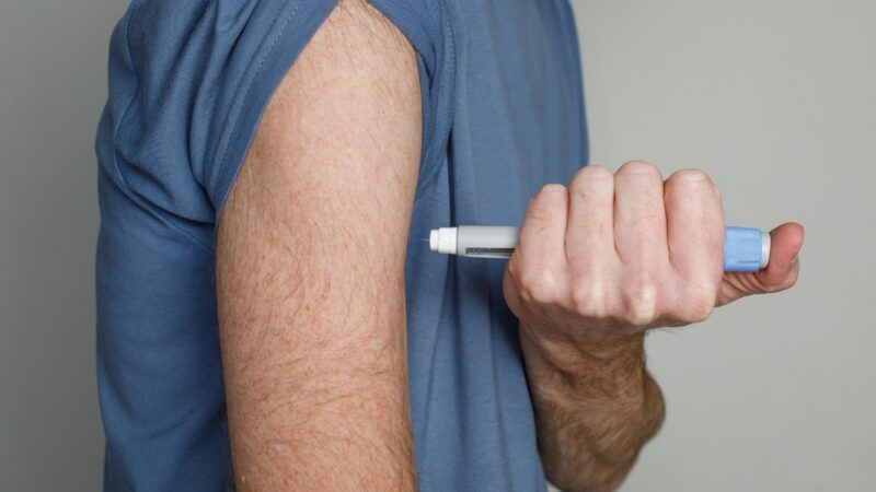 Person holding a semaglutide injection pen near their upper arm