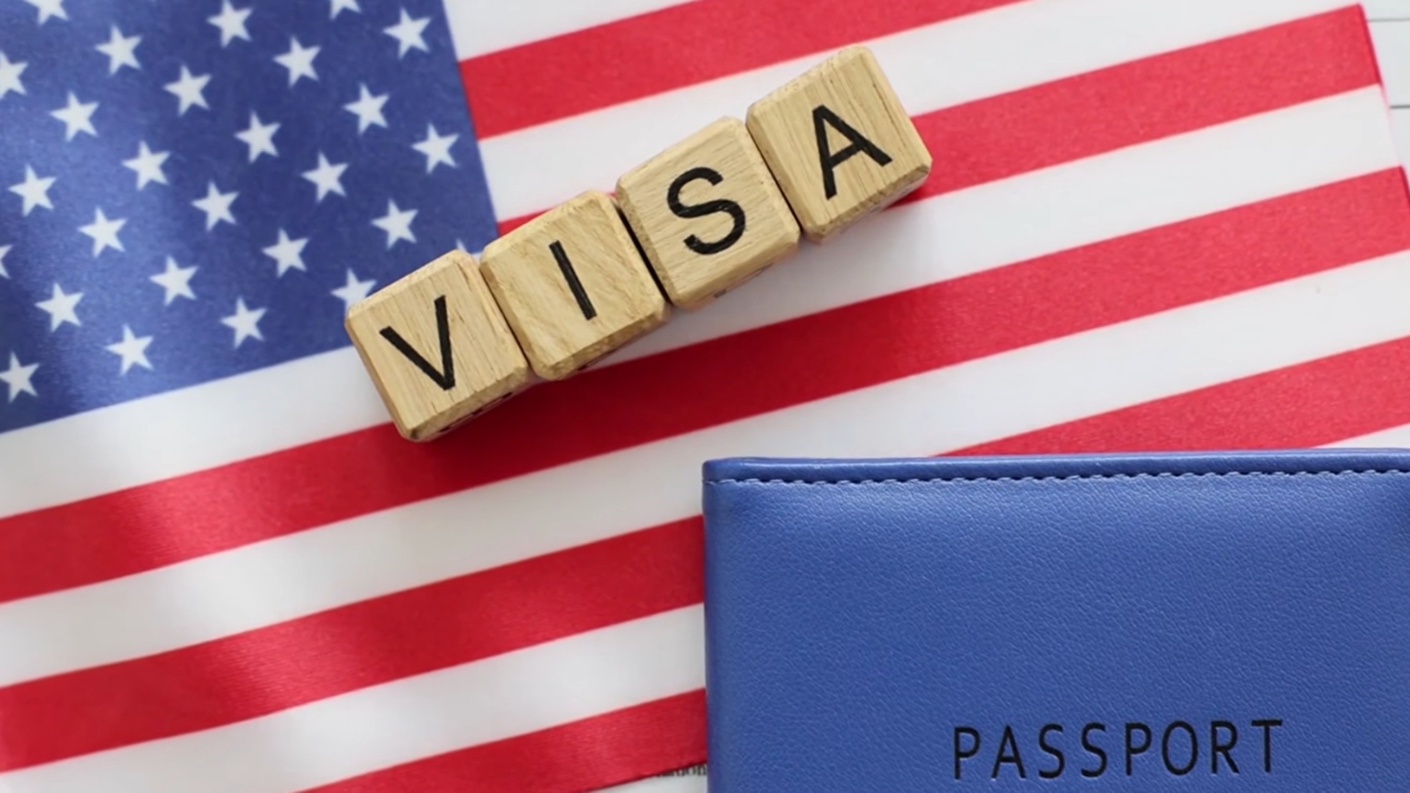 USA flag with “visa” blocks and a passport placed beside them