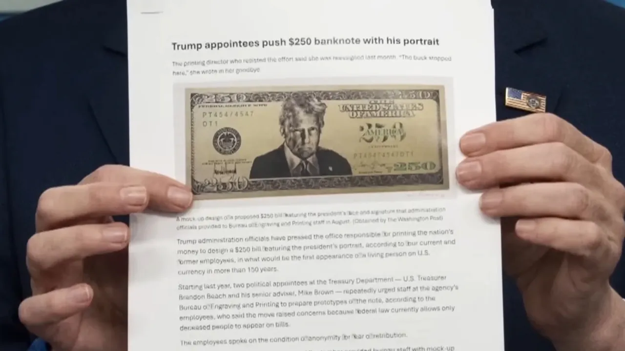 A person holds a printed article about a proposed 250 dollar bill with Donald Trump’s portrait