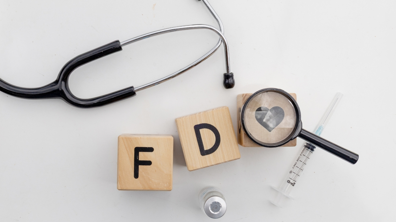 FDA clearance concept with medical tools, letter blocks, and a syringe on a white surface.