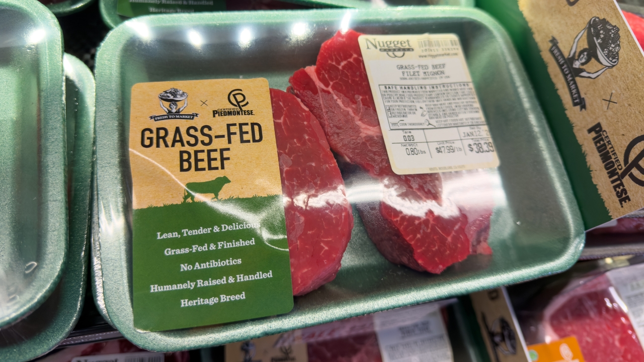 Grass-fed beef packages are displayed in a grocery store meat section